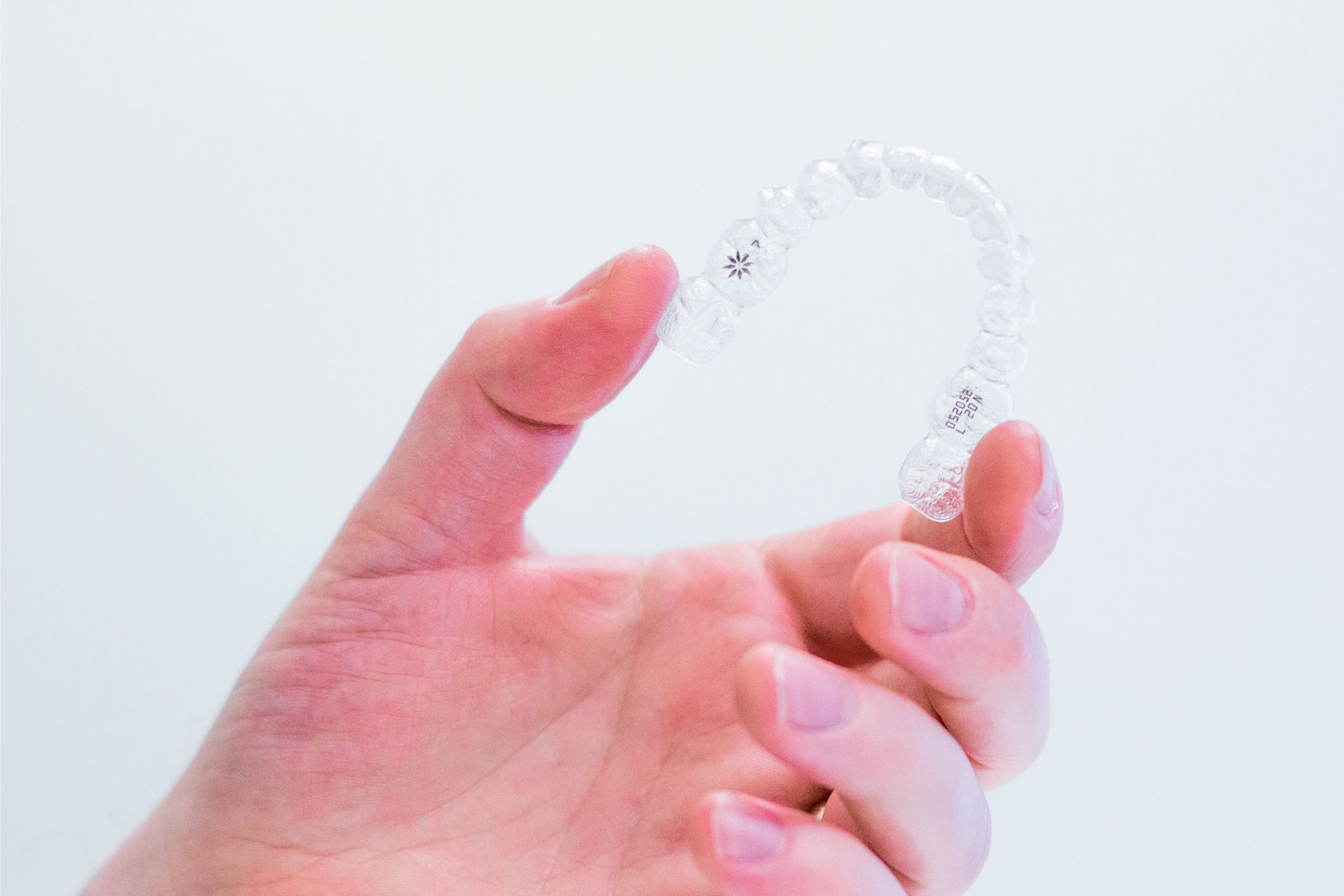 Clear Aligners in Southampton – Facing the Future Orthodontics Hand holding clear aligners used for orthodontic treatment in Southampton at Facing the Future Orthodontics